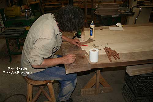 Earl pegging tenons at end of custom made dining table